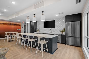 a kitchen with a table and chairs in front of a refrigerator